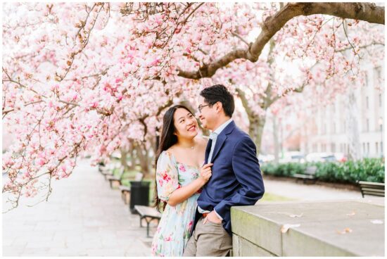 couple laughing under tree covered in tulip blossoms