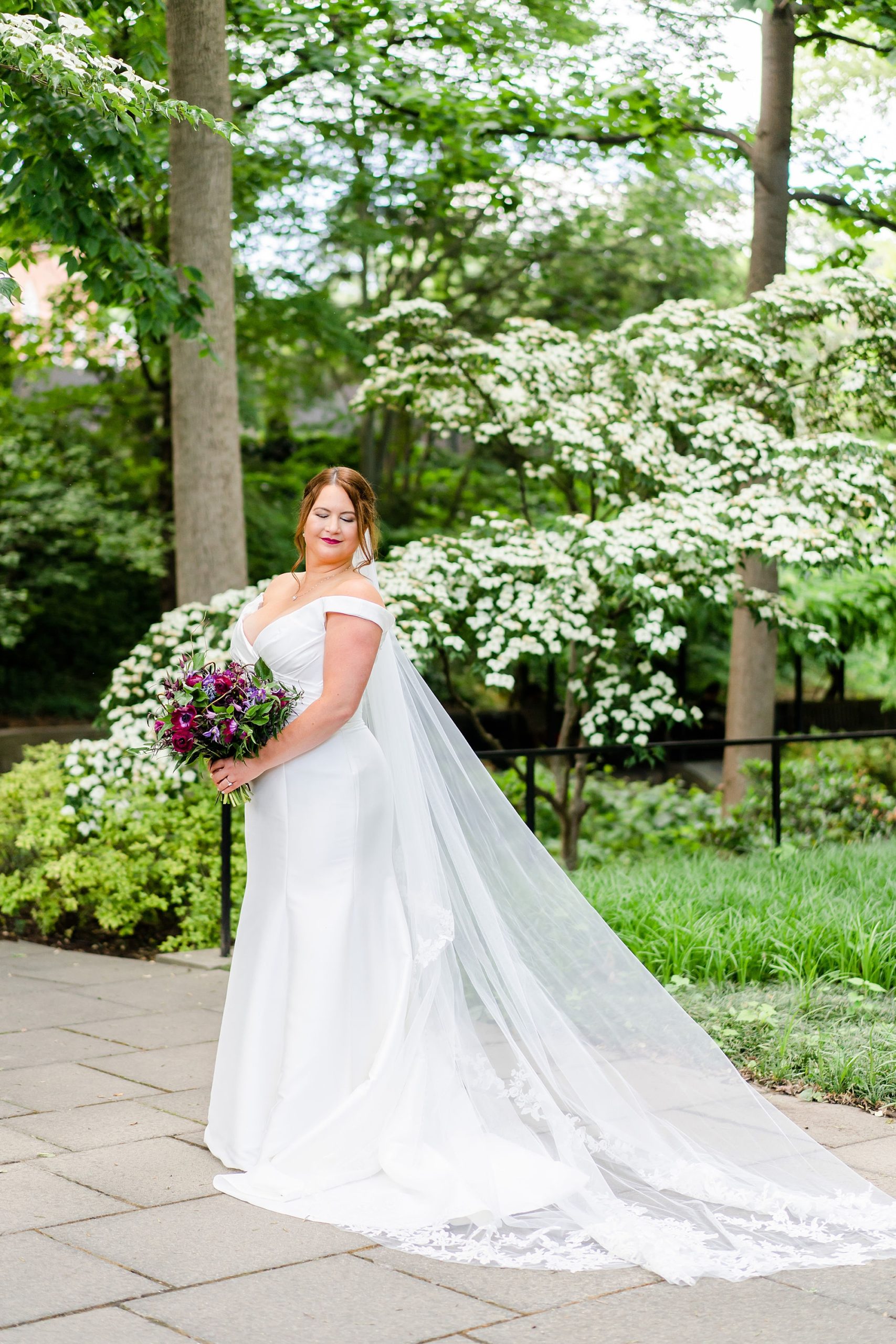 bride stands outside the Baltimore Museum of Art holding bouquet 