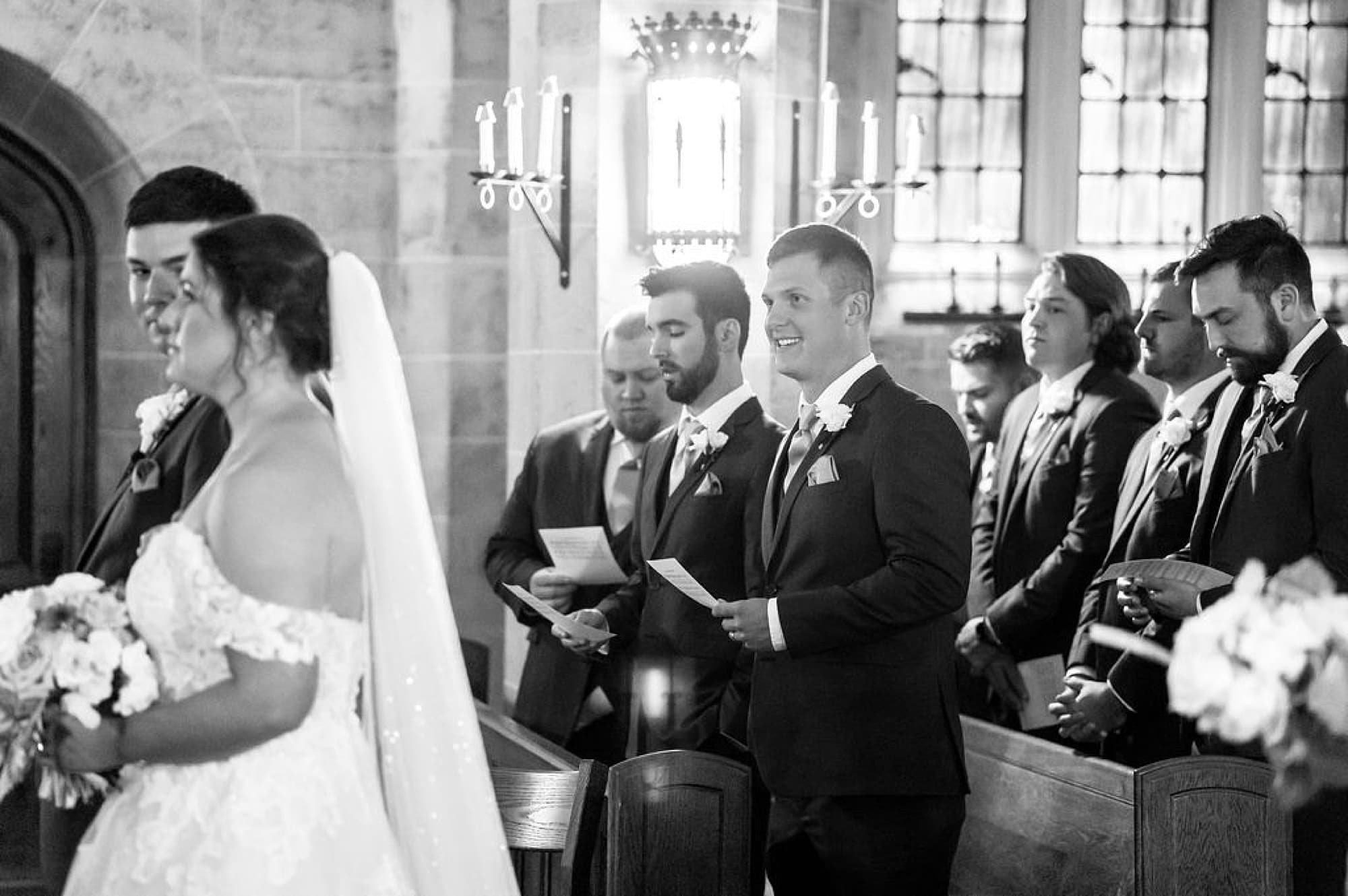 family watches bride walk up aisle during traditional church wedding at Saint Andrews in Delaware