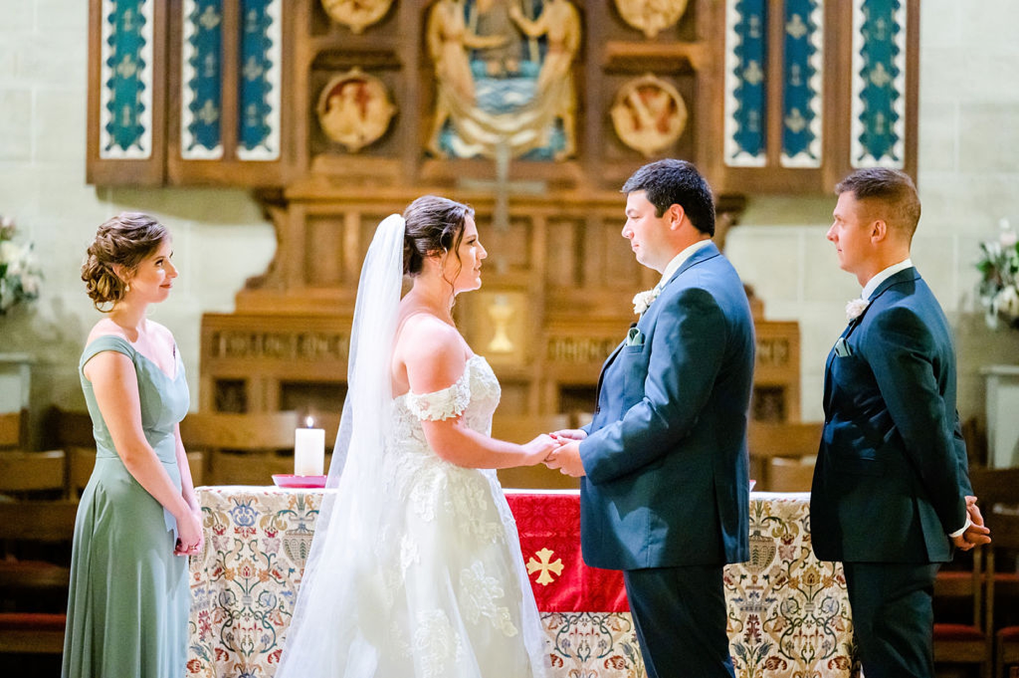 newlyweds hold hands exchanging vows during traditional church wedding at Saint Andrews in Delaware