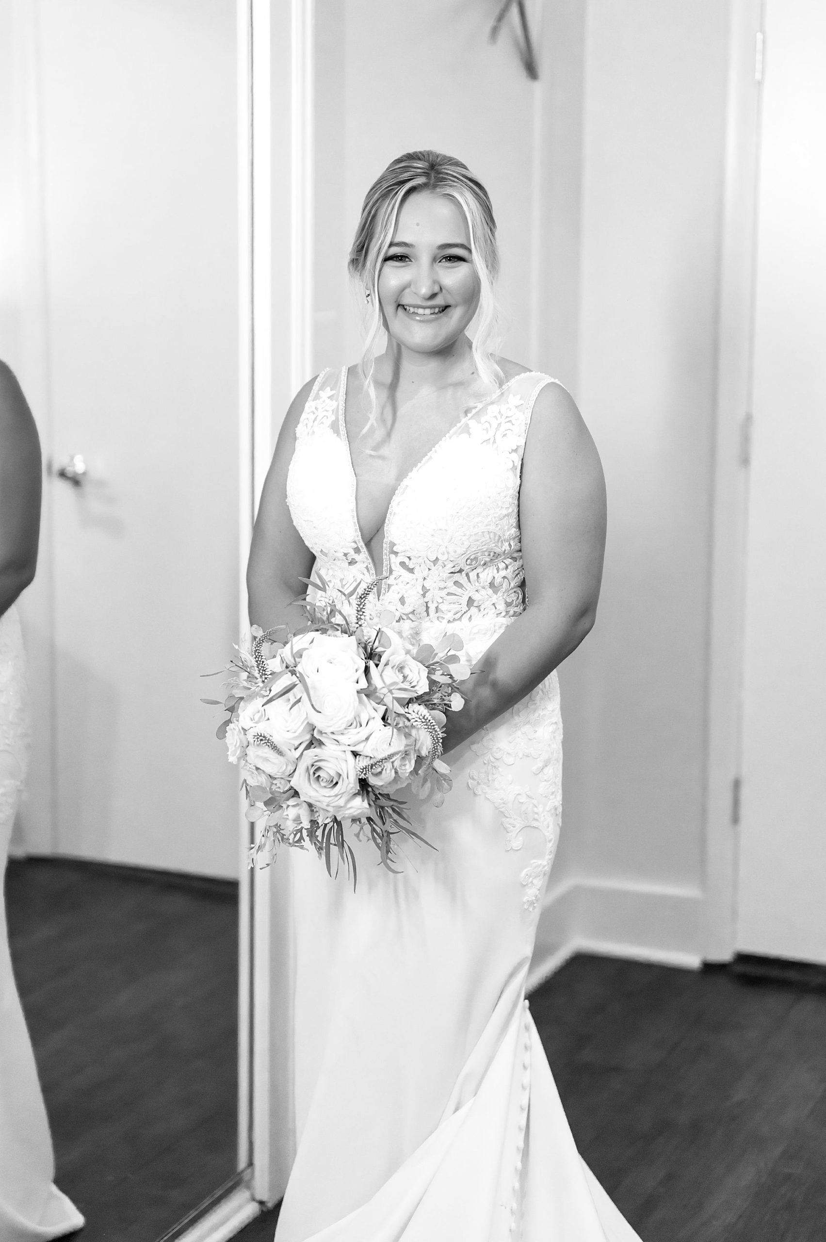 bride stands in wedding dress with bouquet before first look with bridesmaids 