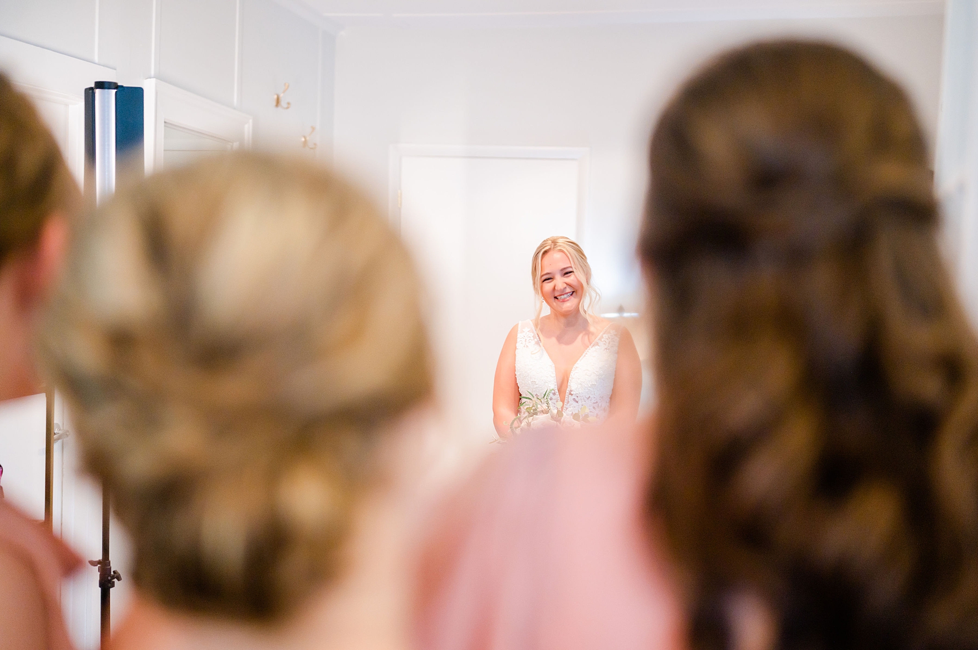 bride smiles at bridesmaids during first look at Londontown Gardens