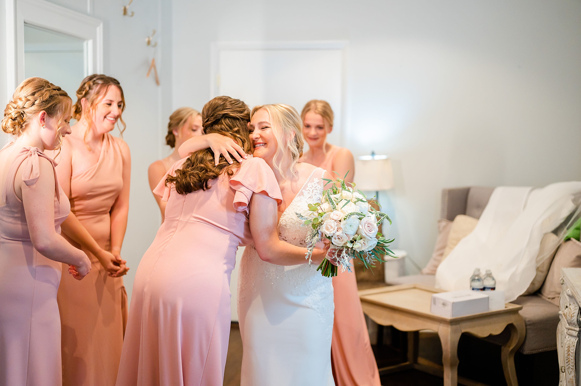 bride hugs bridesmaid in pink gown before Londontown Gardens wedding