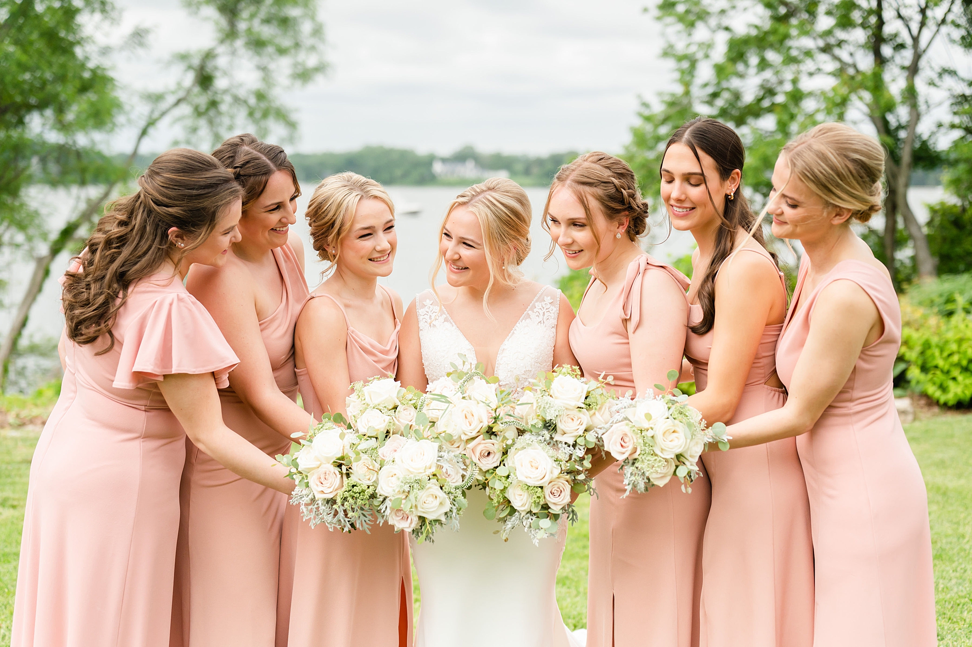 bride smiles at bridesmaids in coral gowns at Londontown Gardens