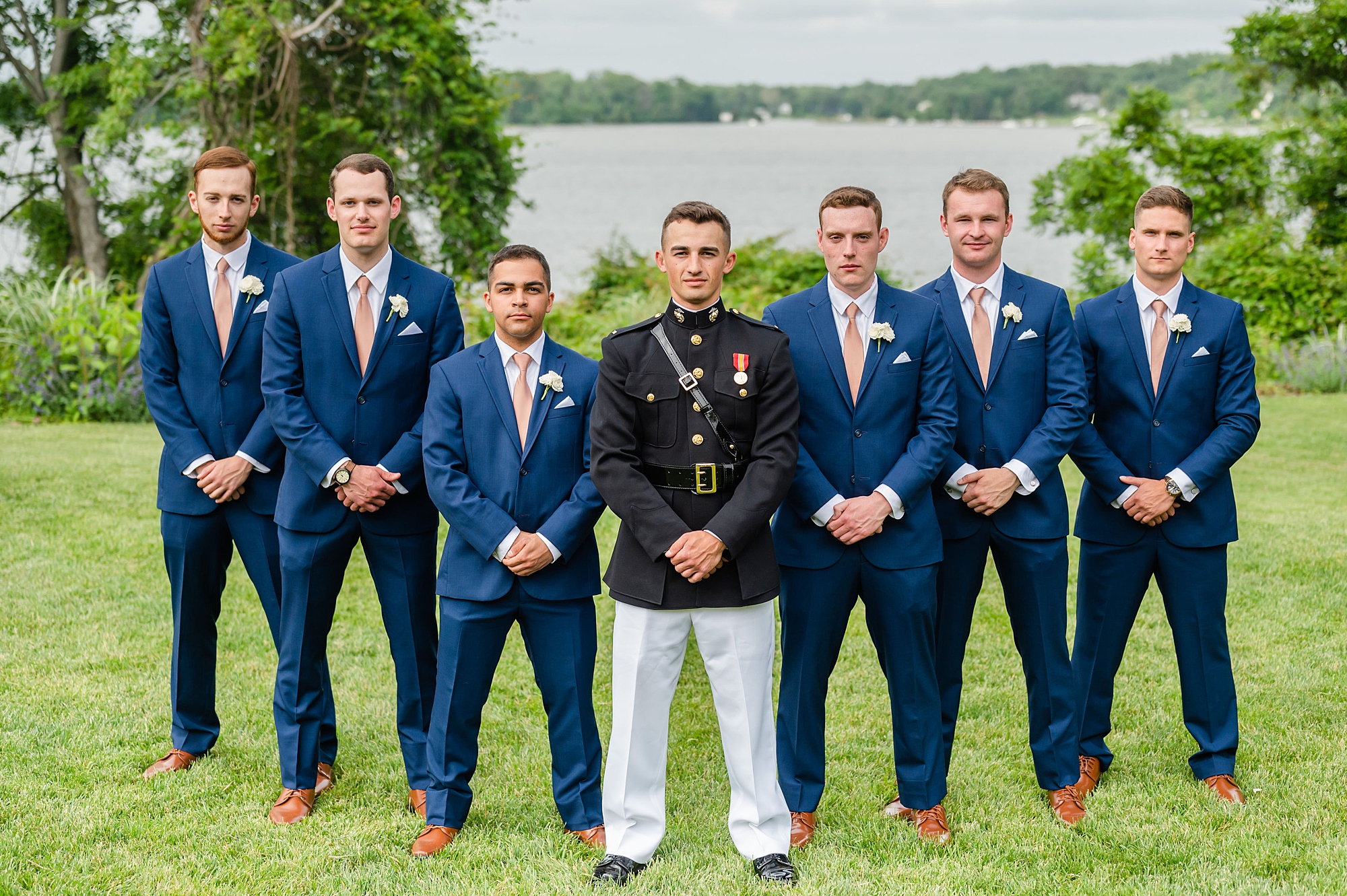 groom stands with groomsmen in navy suits at Londontown Gardens