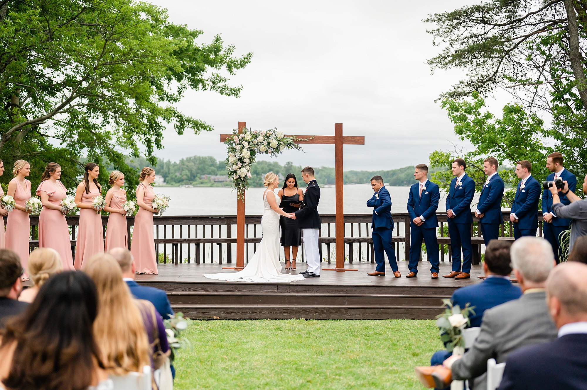 bride and groom stand on wooden stage during waterfront wedding ceremony in Edgewater MD