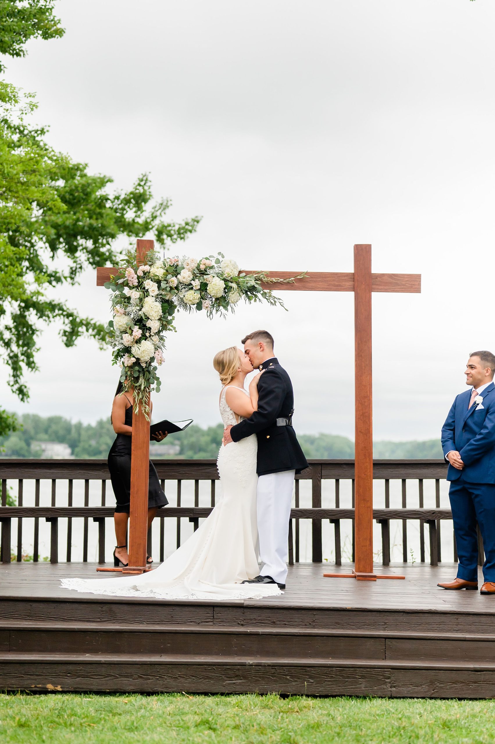 husband and wife kiss during waterfront wedding ceremony in Edgewater MD