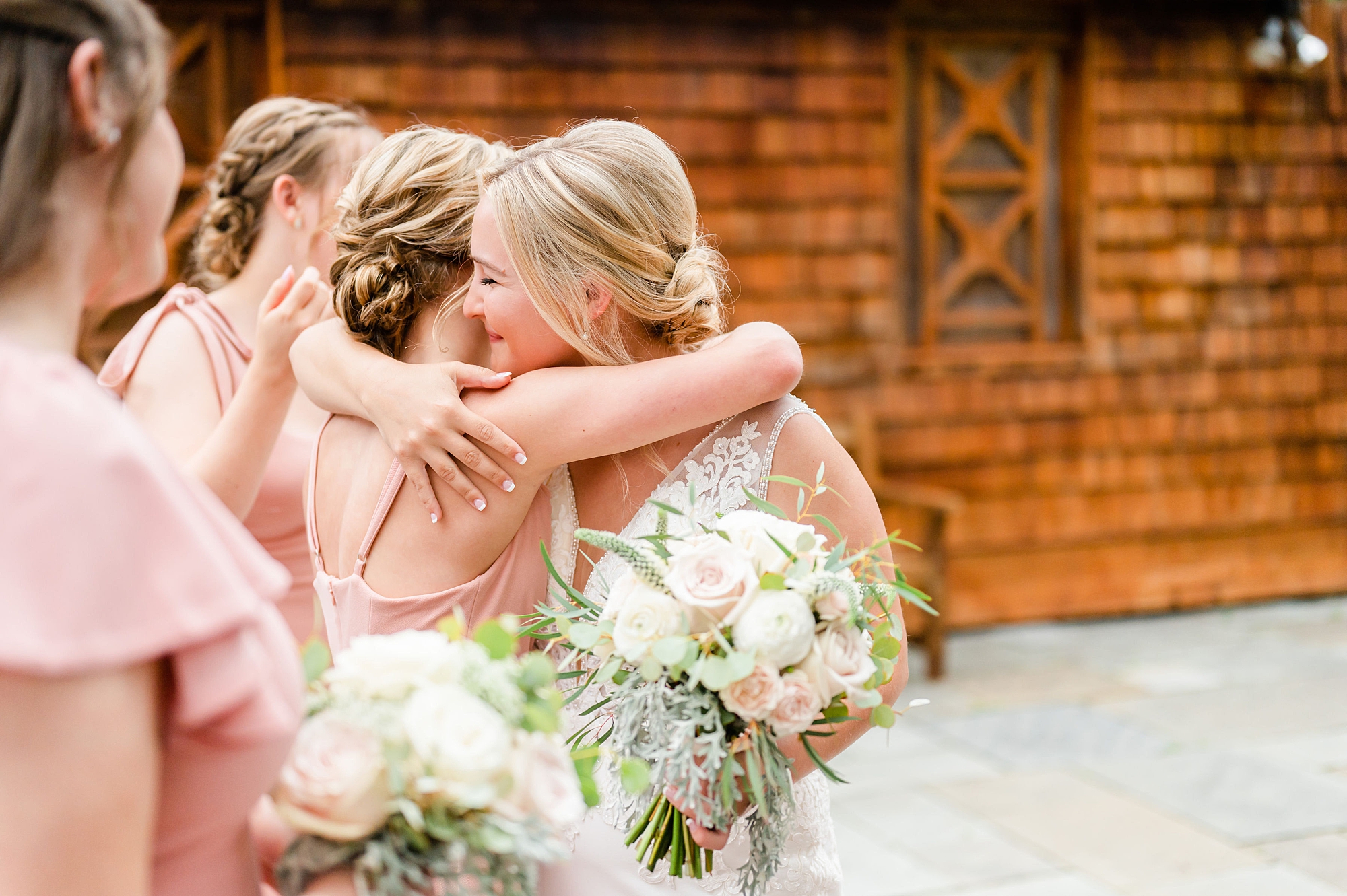 bride hugs bridesmaids after wedding ceremony 