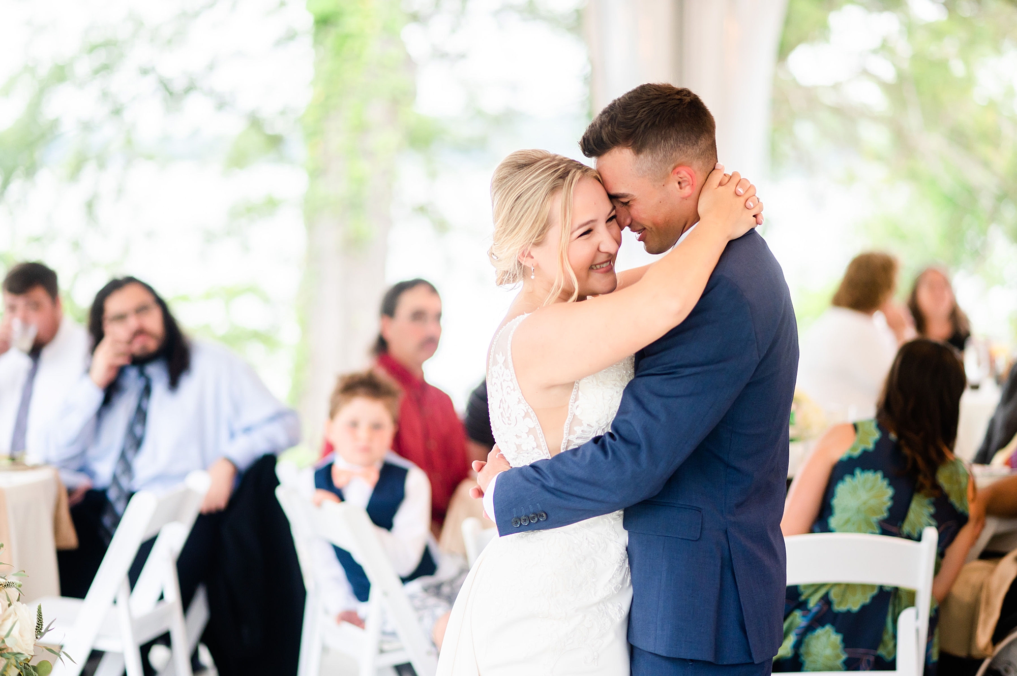 groom laughs into bride's cheek during wedding reception 