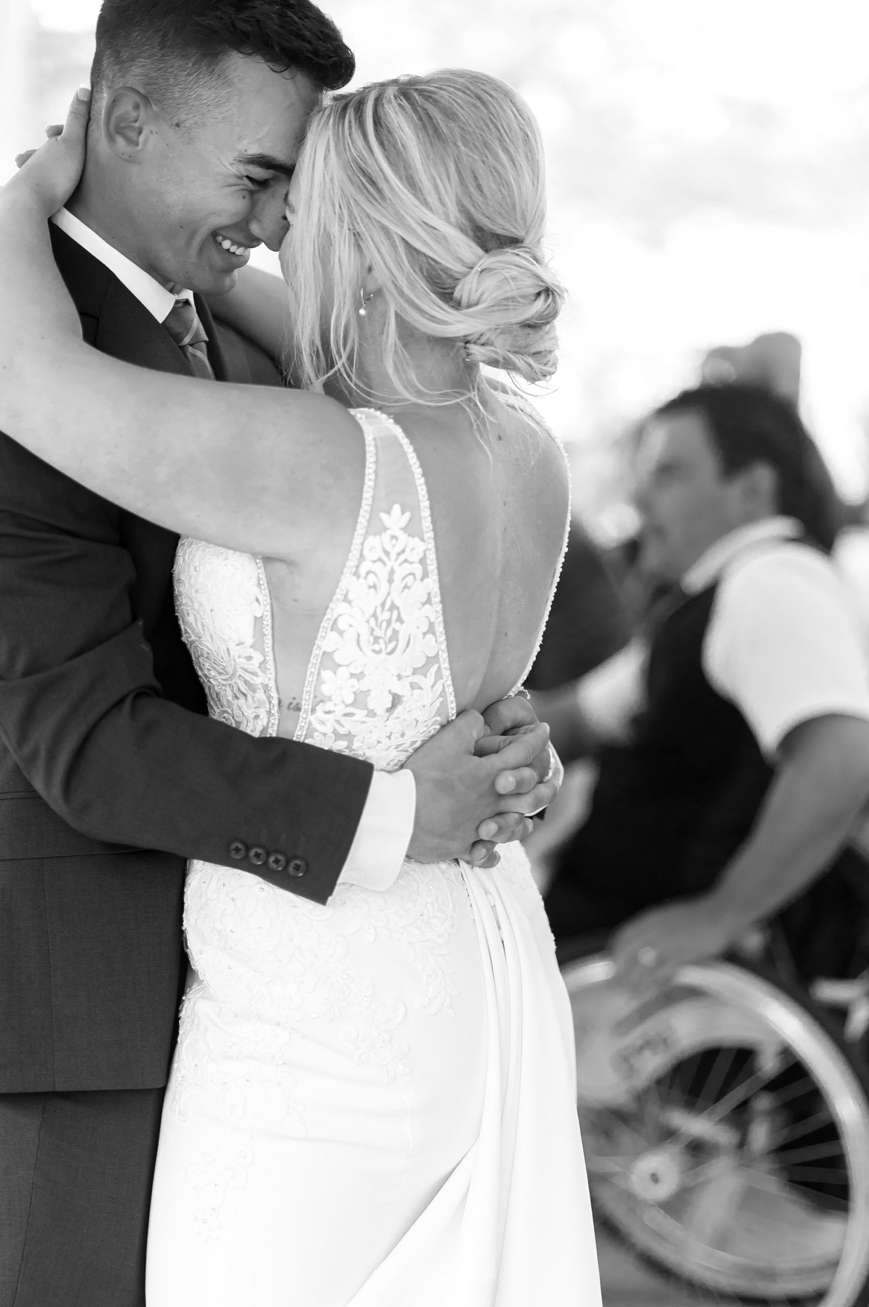 bride and groom hug during first dance smiling 