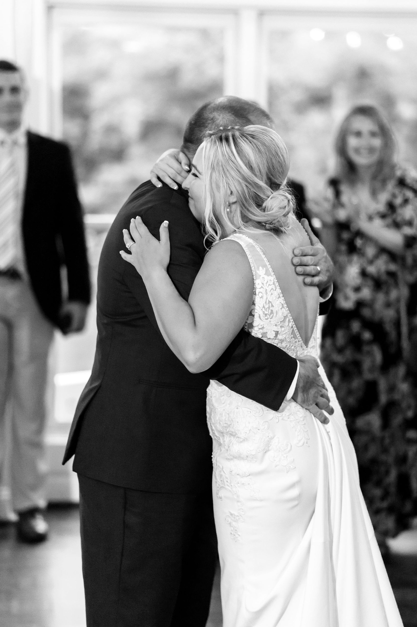 bride and dad hug during wedding reception 