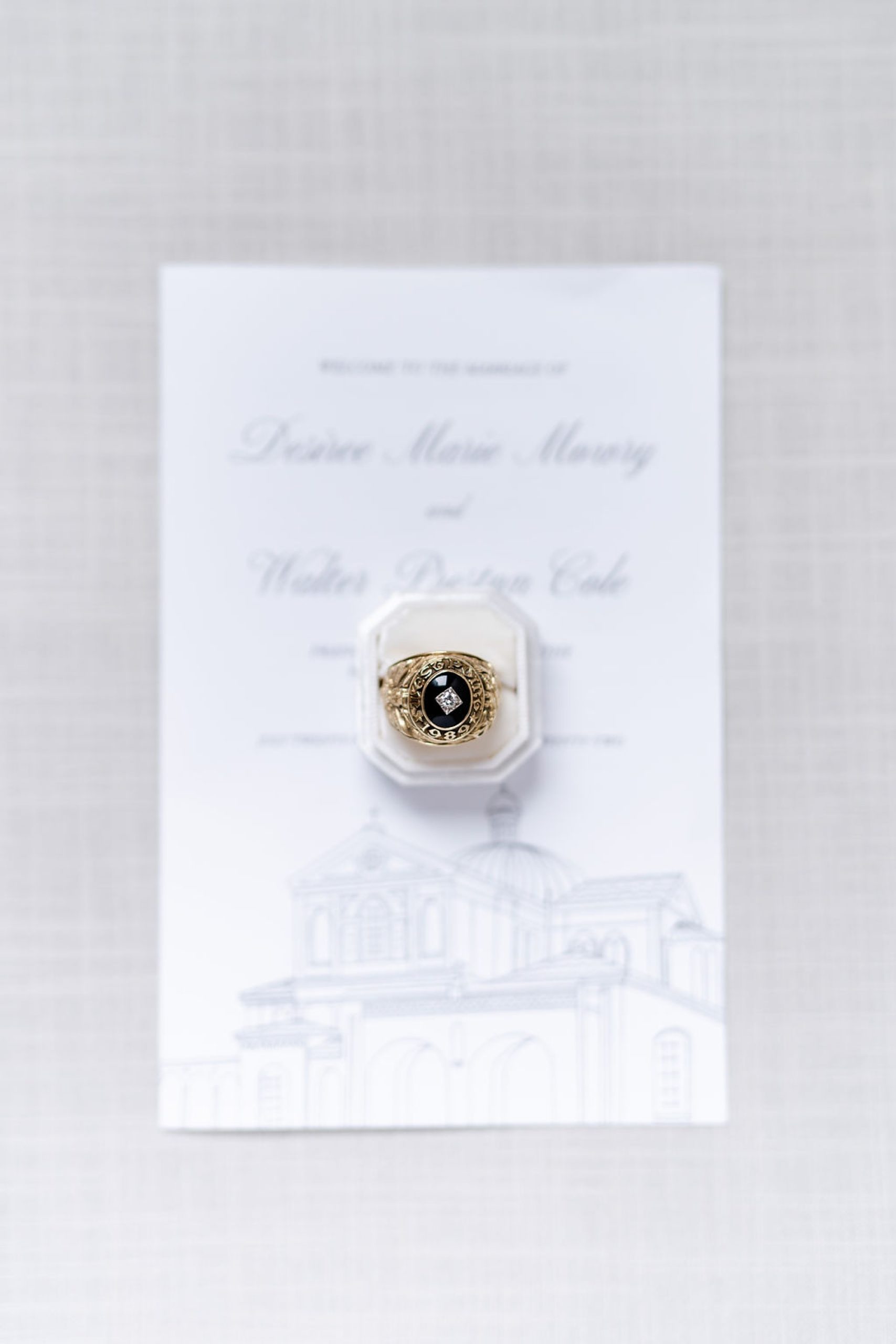groom's military ring rests on invitation for DC wedding