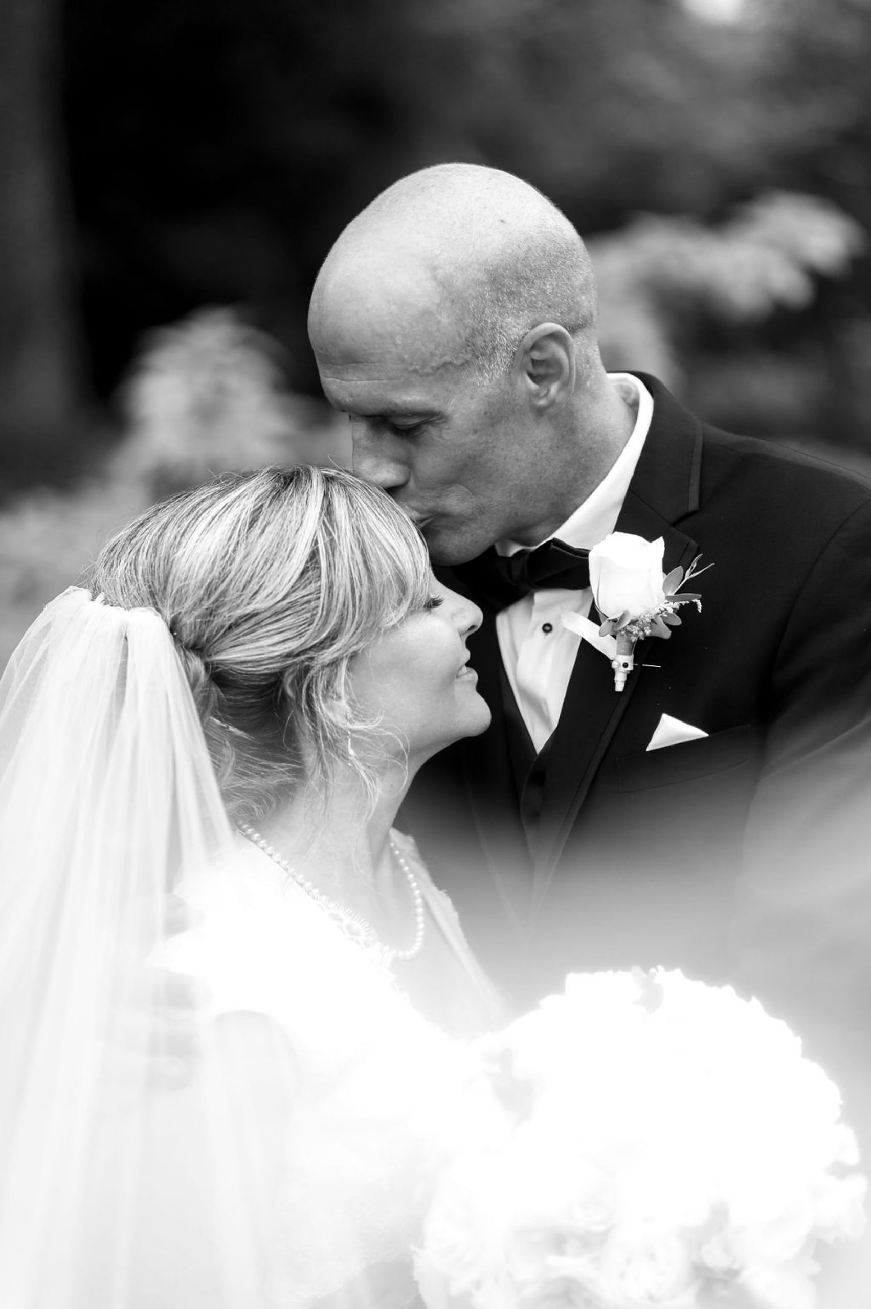 groom leans to kiss bride's forehead during Dc wedding portraits 