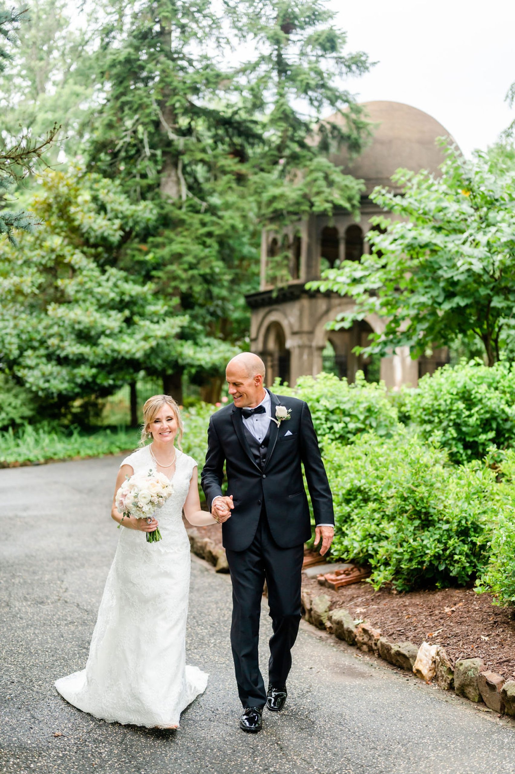 groom smiles at bride during walk in Saint Francis Hall