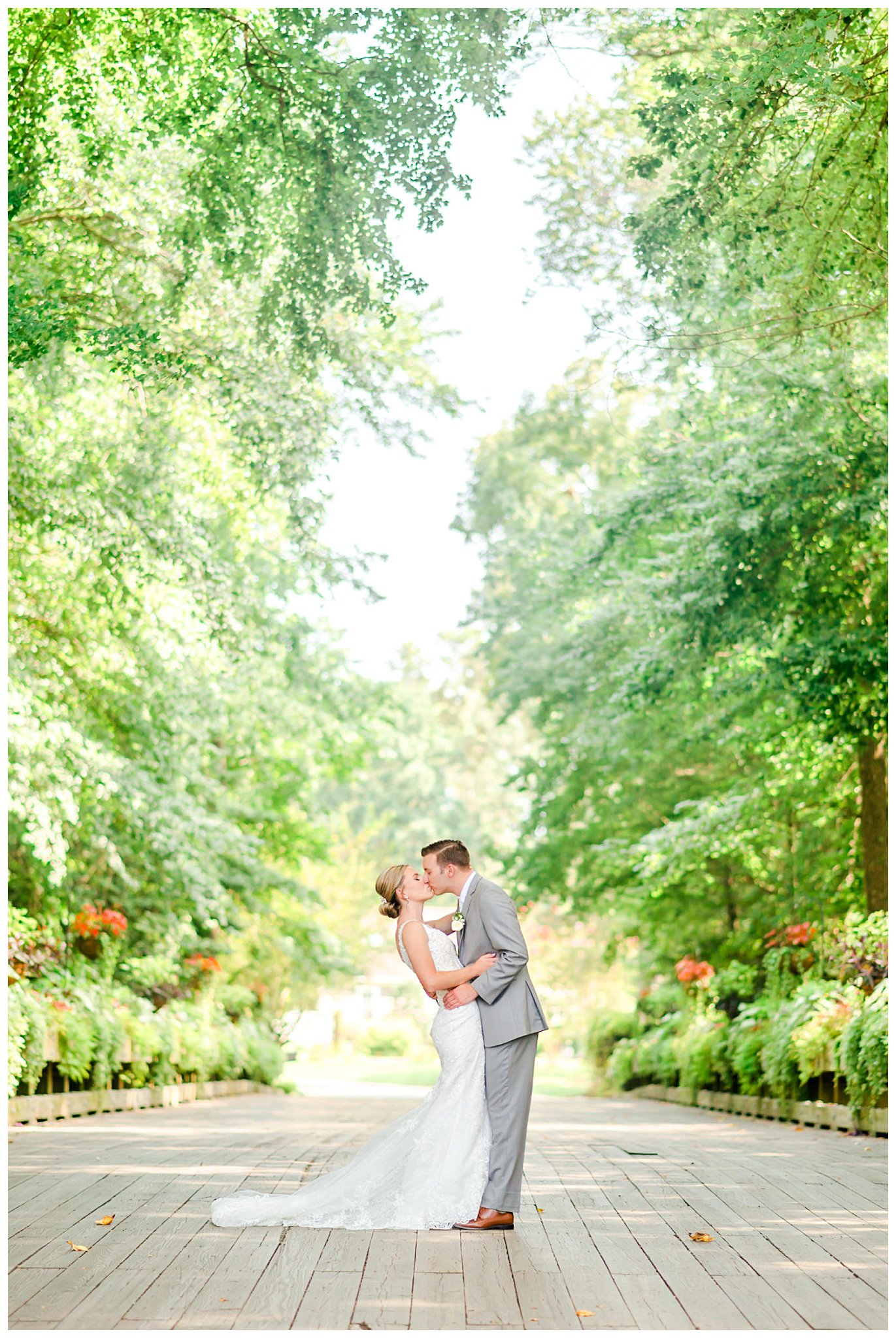 bride and groom kiss in gardens of The Club at Baywood
