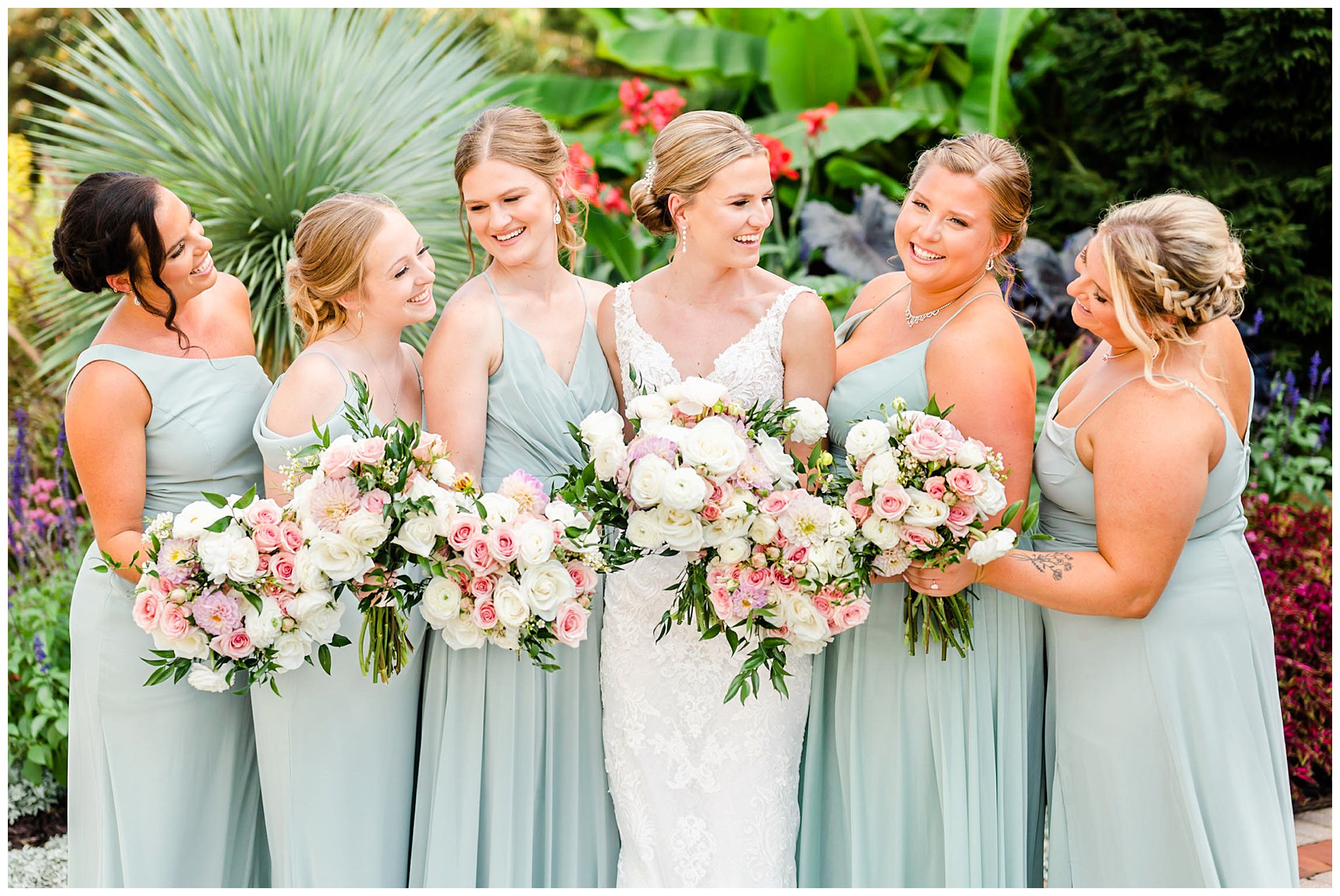 bride smiles with bridesmaids in sage green gowns