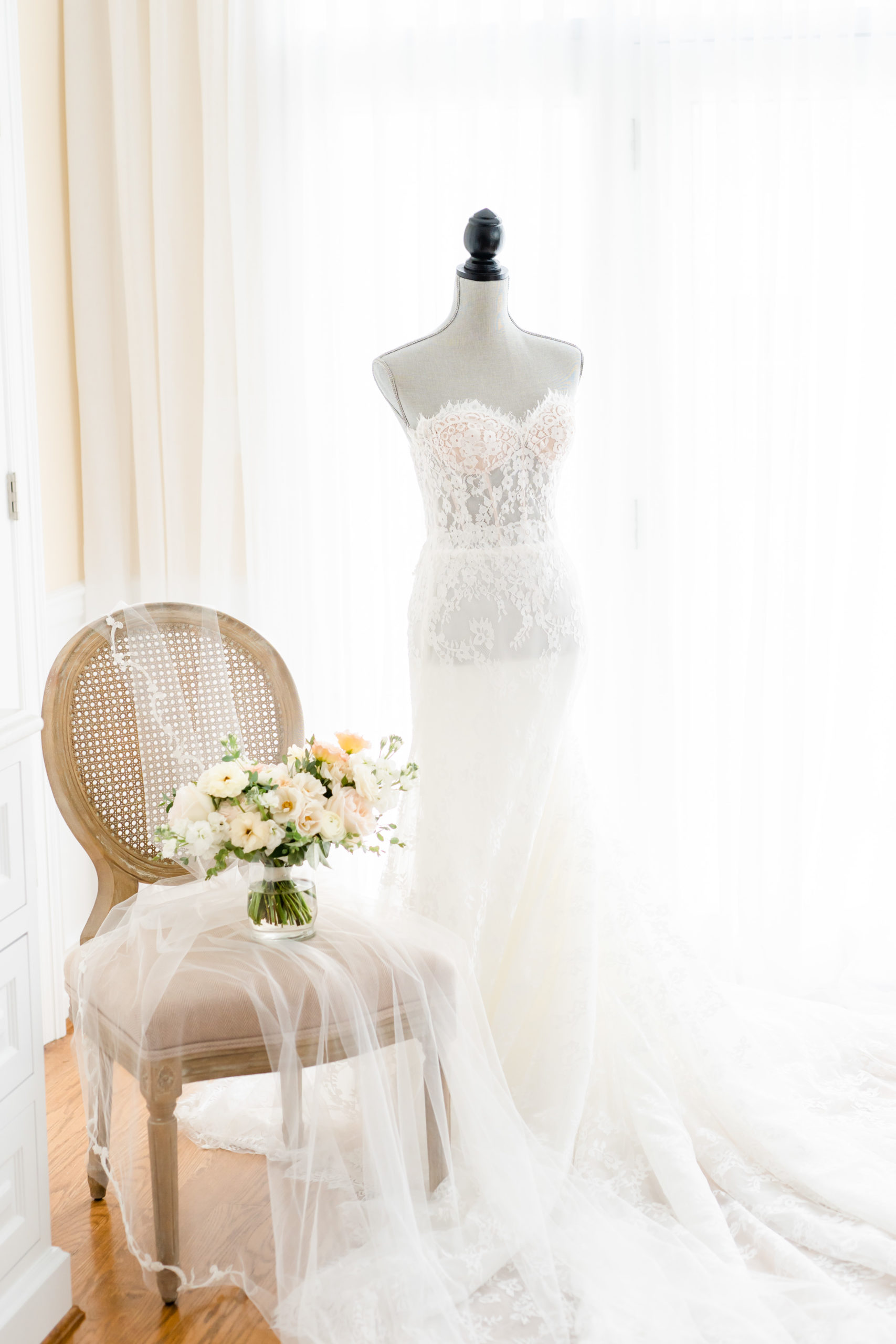 wedding dress and bouquet on tan chair