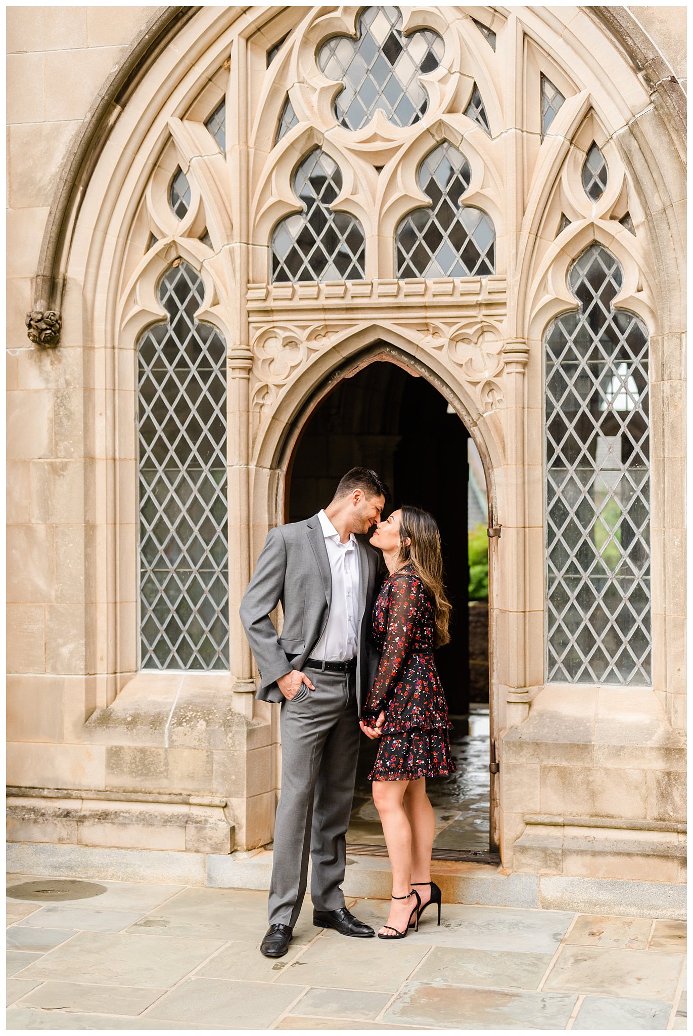 man and woman lean for kiss outside stone doorway at the National Cathedral