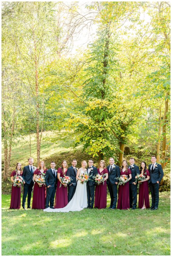 Wedding Party stands under tree