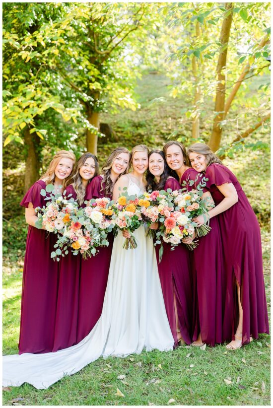 A group of bridemaids standing close together smiling at camera